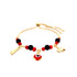 The Red and Black Evil Eye, Figa hand and Elephant lucky charm bracelet features a 14k gold-filled chain adorned with vibrant red and black beads. This elegant accessory includes three distinct charms: a dangling red and black circular charm, a gold figure charm, and a gold elephant. The adjustable chain ends provide the perfect fit for this fashionable bracelet.